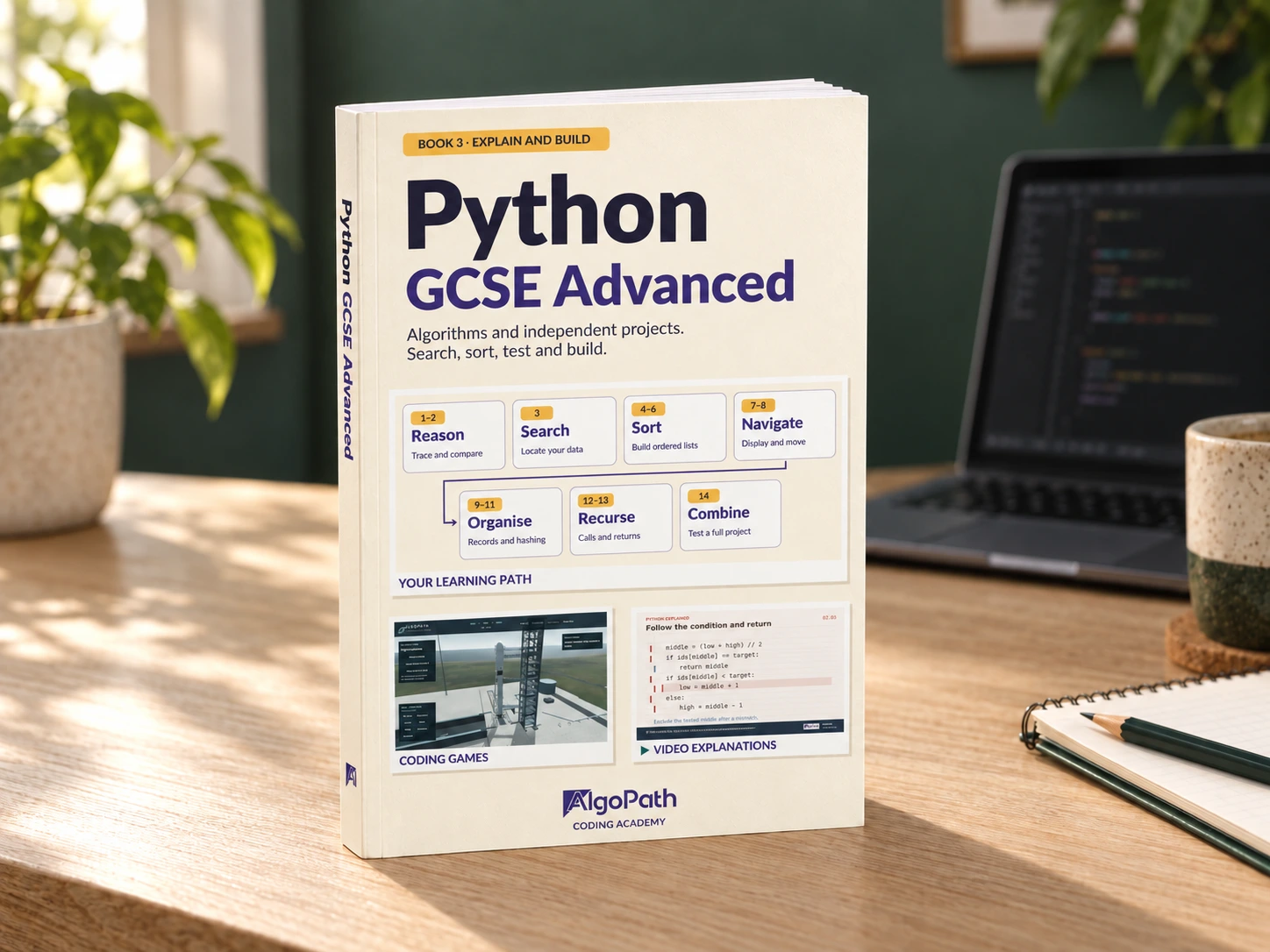 3D print mockup of Python GCSE Advanced, showing its cover, spine and page edges on a wooden desk in a coding workspace.